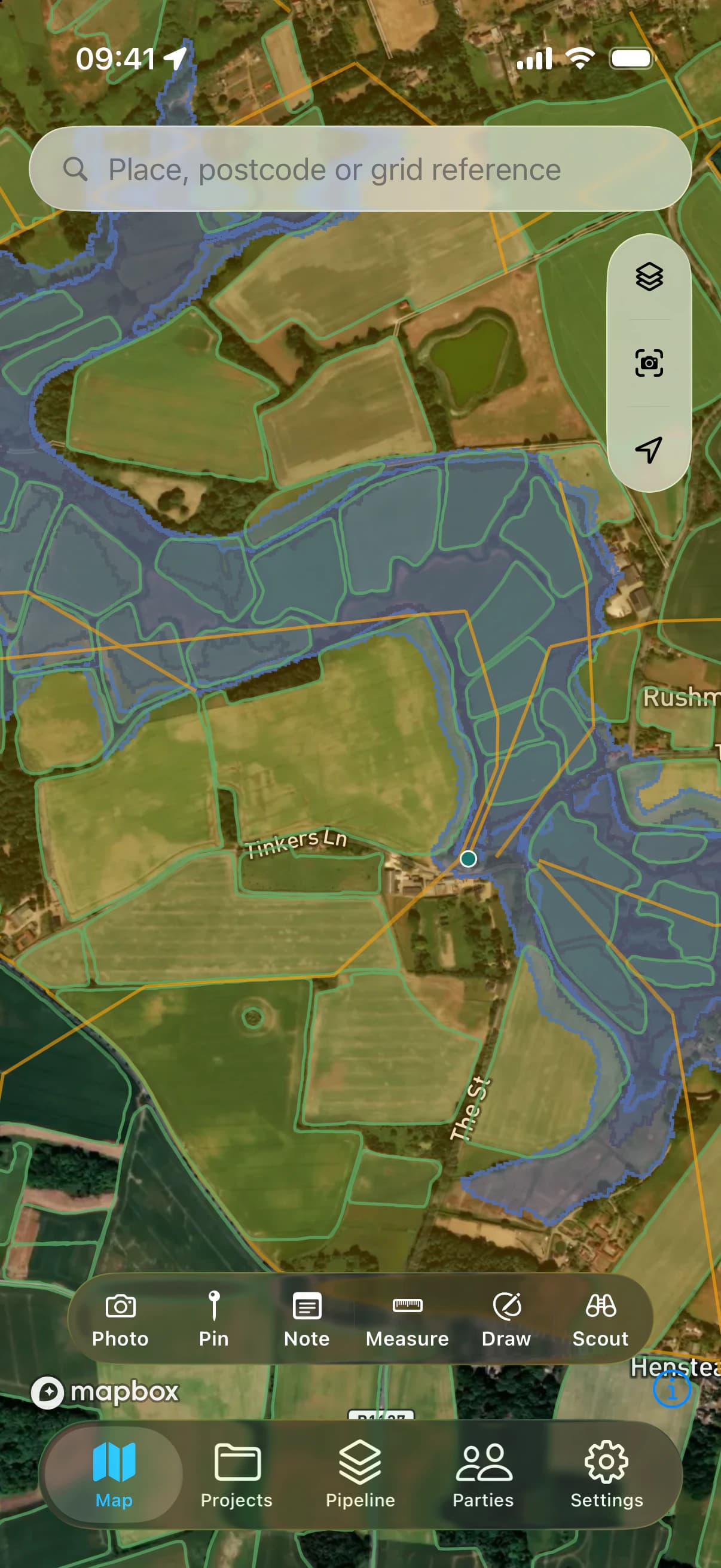 The LandAreas map on iPhone: field boundaries, flood risk and power lines over satellite imagery of Suffolk.